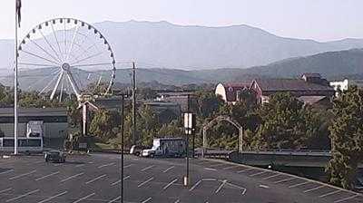 Bright Ferris wheel at Smoky Fans Social event with scenic mountain backdrop.